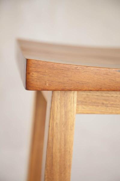 This is a close up of left corner edge of a bar chair. These high bar chairs are made from blackwood. The height can be customised to fit into most spaces. 