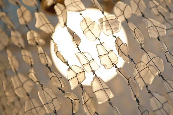 This is a chandelier made with 500 glass beads lit up to create an ambience in the bedroom. The hoops of our chandeliers are made from galvanised steel from old wine barrels. 