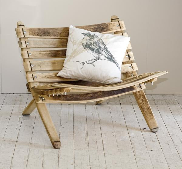 This is a loveseat made from oak, with a cushion on it. 