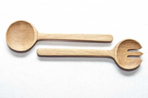This is a bird’s eye-view of a pair of wooden salad servers made from recycled oak. 